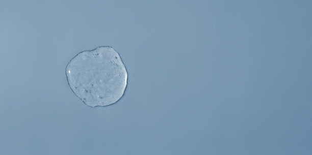 蓝色背景上滴一滴卫生凝胶图片下载