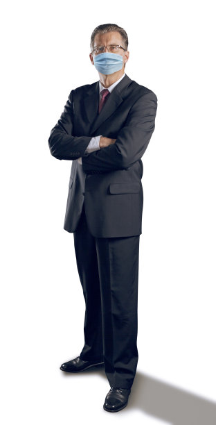 戴着Covid-19口罩的商人在白色背景下看着摄像机图片下载