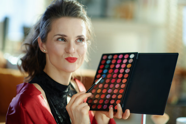 沉思女性与唇调色板在现代房子在阳光明媚的日子图片下载