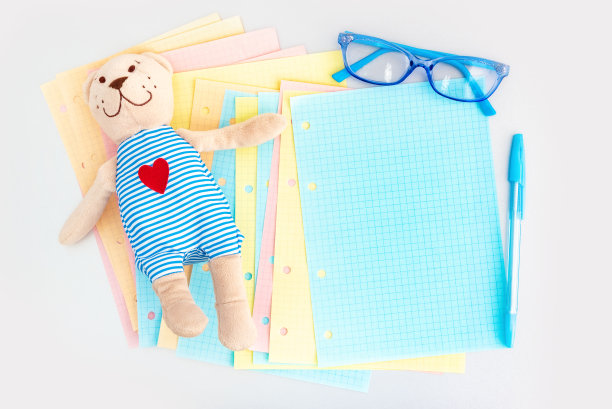 不同颜色的折叠笔记本上的空白格子页散落在银色的桌子上图片下载