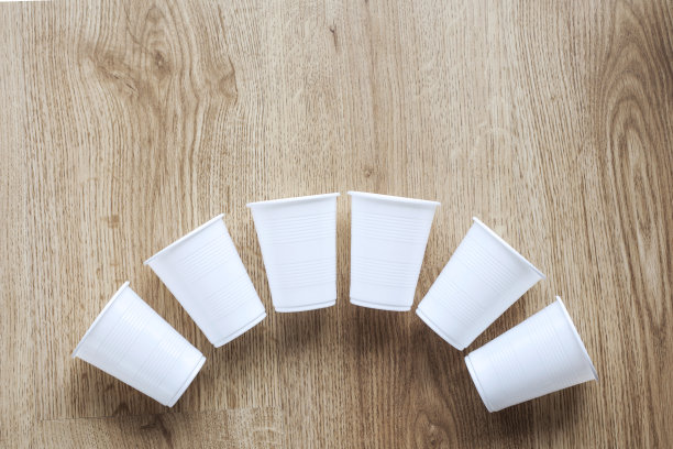 木制背景上的一组塑料杯图片下载