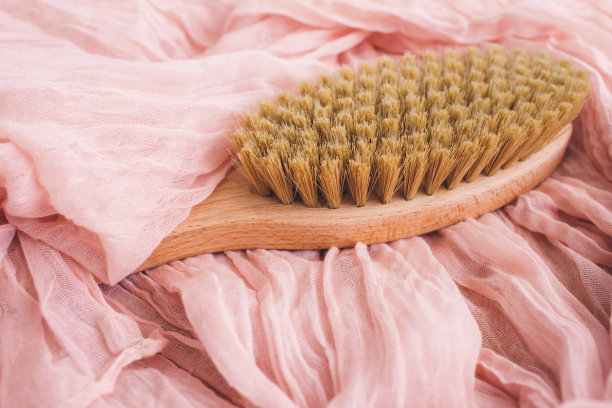 木制刷在粉红色背景干按摩。侘寂的美学。天然材料。图片下载