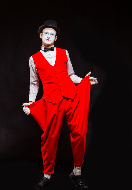 男性哑剧艺术家的肖像，孤立在黑色背景上。年轻人拿出空空的口袋。贫穷，缺钱，低工资的象征图片下载