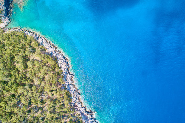 落基的海岸线和明亮清澈的大海在阳光明媚的一天顶部向下鸟瞰图片下载