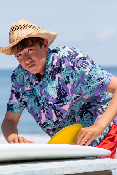 日本青少年冲浪者建立一个亮黄色鳍冲浪板图片下载