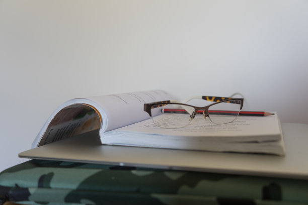 一张笔记本电脑和课本的照片，上面有老花镜和铅笔图片下载