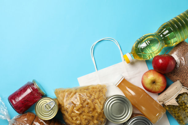 不同的食物在蓝色背景，俯视图。捐赠的概念图片下载