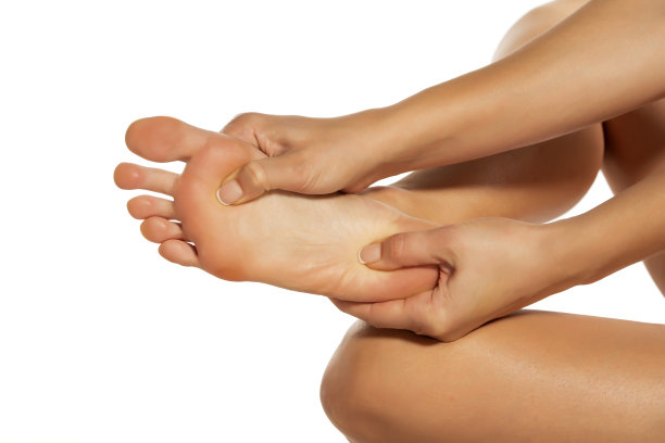 女人按摩她疼痛的脚在白色的背景图片下载