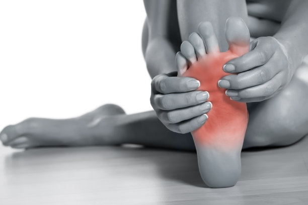 女人在白色皮肤上按摩她疼痛的脚图片下载