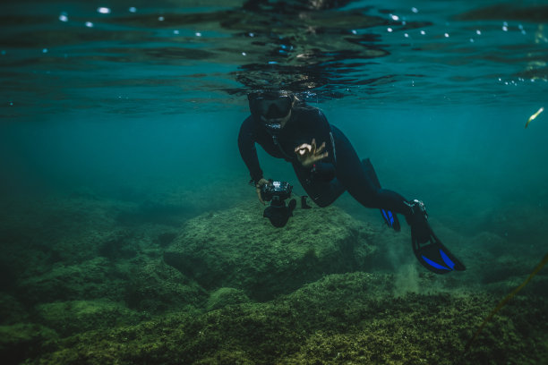戴水肺的潜水员探索水下的礁石图片下载