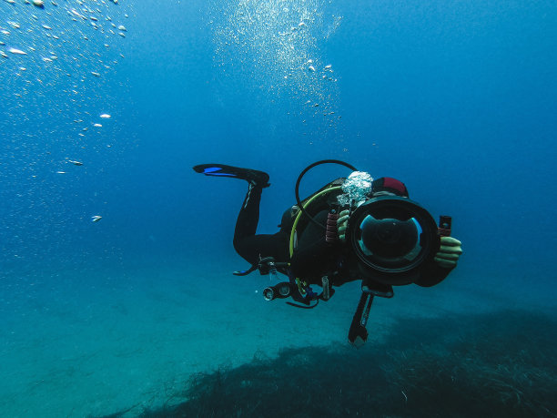 戴水肺的潜水员探索水下的礁石图片下载