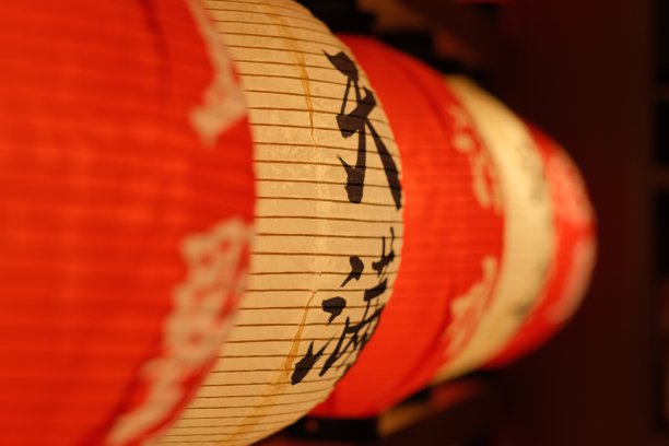 近一排传统的日本红白灯笼。透视和模糊背景。图片下载