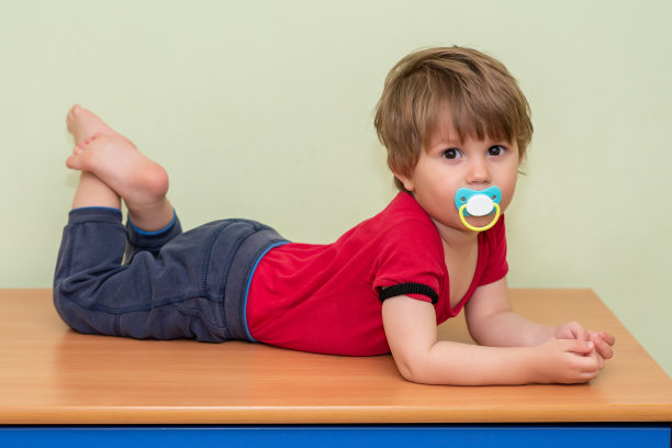 一个拿着奶嘴躺在壁橱里的男孩图片下载