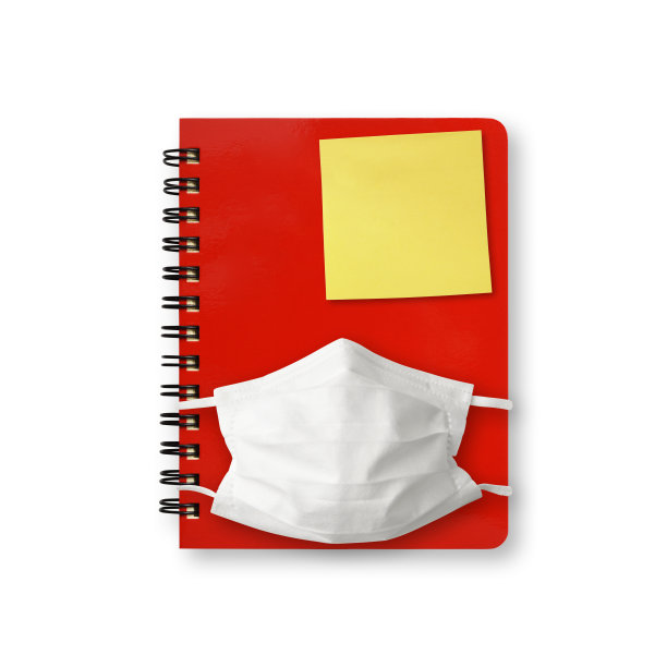 白色背景上的封闭式螺旋笔记本、防护口罩和黄色便签图片下载