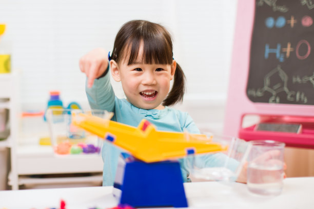 蹒跚学步的女孩玩平衡玩具在家上学图片下载