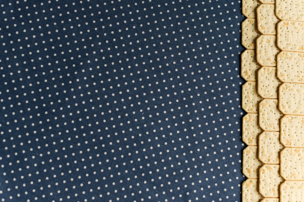 一张盐饼干的照片，从顶部拍摄的蓝色圆点背景与复制空间。图片下载