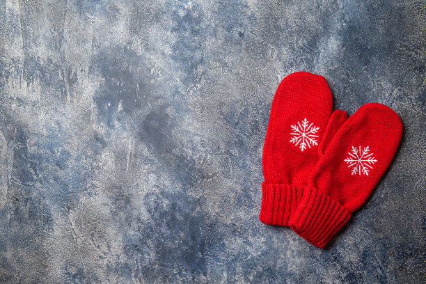 圣诞和新年温馨的节日组合:围巾，女人手戴手套，灰色的混凝土背景上放着热饮料和棉花糖的杯子。平躺，俯视图图片下载