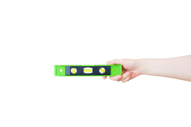 建筑泡沫塑料水平在一个白种女人的手中。白色的隔离。图片下载