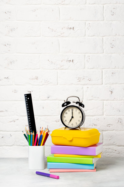 9月1日返校。闹钟，书，笔记本，铅笔和饭盒在桌子上。图片下载
