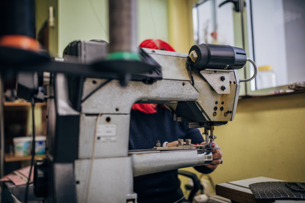 一位在缝纫机上工作的成熟红发妇女图片下载