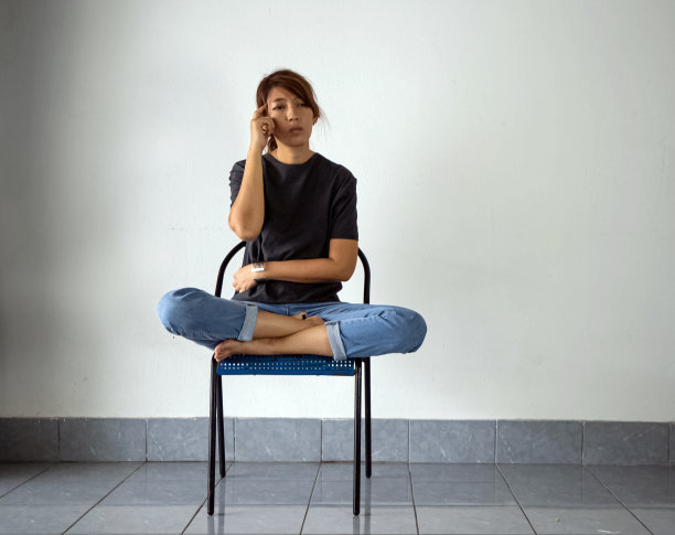 有压力和不安情绪，坐在椅子上，抬起手指触摸头部的女人。有精神问题。抑郁症综合征图片下载