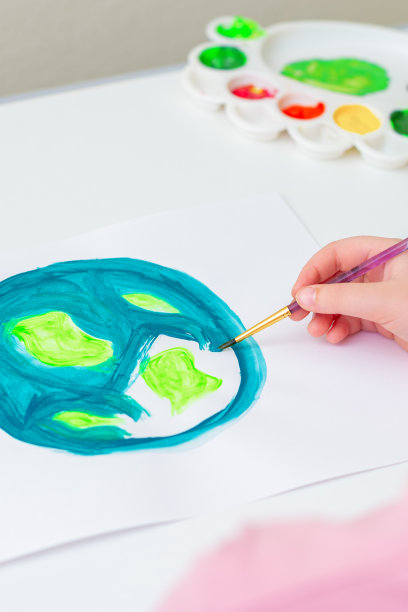 小女孩正在画地球。图片下载