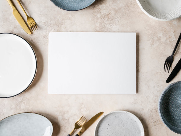 各种空白的盘子和器皿和白色空白表在中心的文字浅棕色的背景。前视图。本空间图片下载