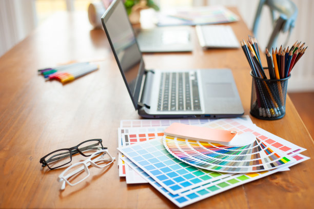 颜色样本与笔记本电脑在设计师的办公桌上。在家工作。图片下载