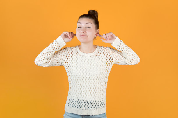 女孩用手指塞住耳朵，微笑着闭上眼睛，不想听任何东西图片下载