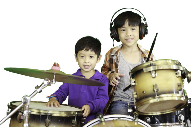 音乐教室里一对可爱的兄弟和一个鼓的肖像。图片下载