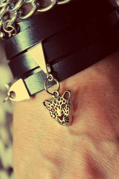手工皮革和银手链与虎头，近距离时尚珠宝照片。图片下载