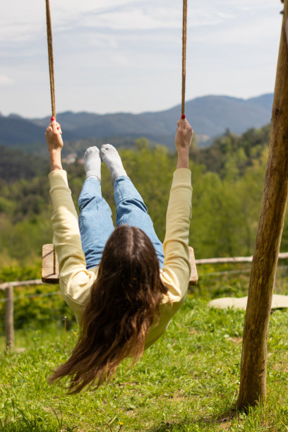 一个阳光明媚的日子，年轻的黑发女子赤脚在公园外晃荡。图片下载