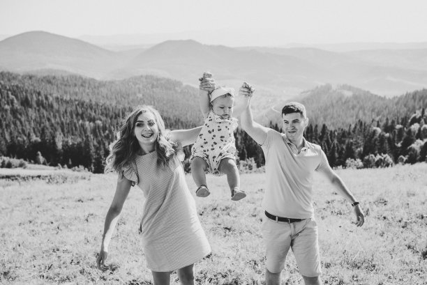 幸福家庭的肖像。妈妈，爸爸和女儿漫步在大自然的群山中。年轻的家庭一起度假，户外活动。暑假的概念。黑白照片。图片下载