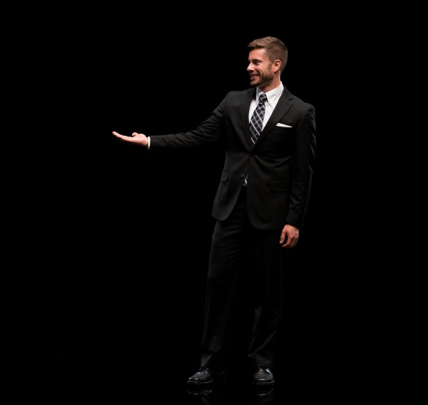白人年轻男性主持人穿着商务服装站在黑色背景前图片下载