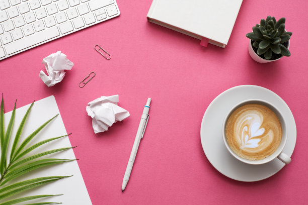 女人的家庭办公桌工作空间与智能手机，耳机和植物在柔和的背景。平躺，俯视图。时尚女性的概念。库存图片图片下载