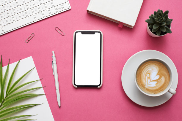 女人的家庭办公桌工作空间与智能手机，耳机和植物在柔和的背景。平躺，俯视图。时尚女性的概念。库存图片图片下载