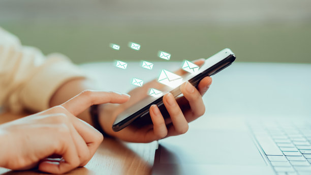 通信网络的概念。女人用手按智能手机，手机上显示电子邮件图标。图片下载
