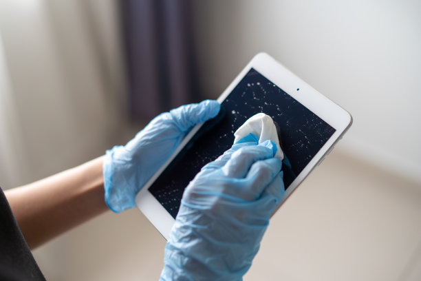 年轻的亚洲妇女手与手套消毒数字平板与消毒擦拭图片下载