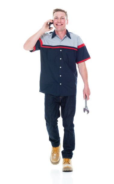 白人年轻男性汽车修理工走在白色背景，穿着制服，手持开口扳手和使用手机图片下载