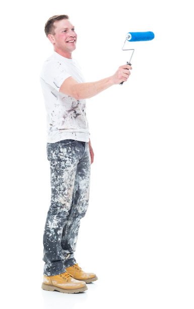 白人年轻男性房屋油漆工站在白色背景前，拿着油漆滚筒图片下载