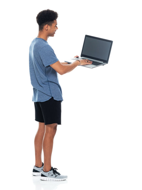 z一代十几岁的男孩穿着运动鞋站在白色背景前使用电脑图片下载