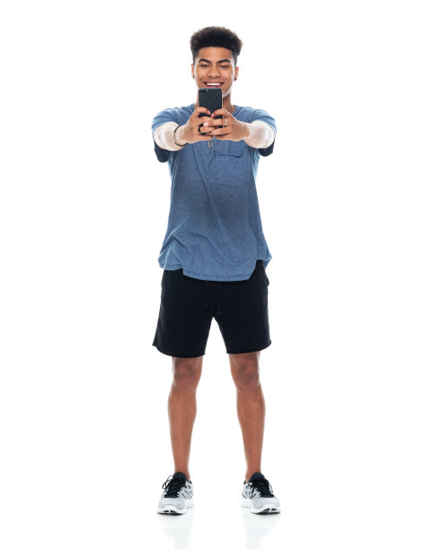 z一代的少年们穿着运动鞋，用手机站在白色背景前拍照图片下载