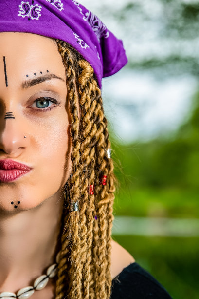 肖像近距离的女人与脸部油漆和编发股票照片图片下载