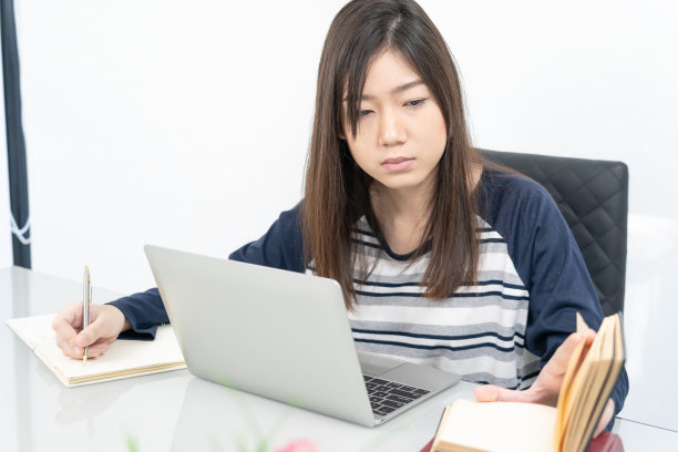 年轻的女学生坐在客厅里，在网上学习图片下载