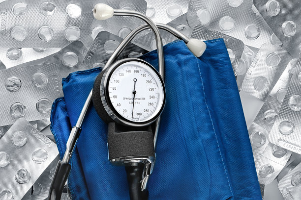 经典的眼压计对抗一堆空药丸水泡。血压监测工具，俯视图。医学设计背景图片下载