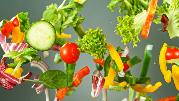 飞行蔬菜沙拉孤立在绿色背景。图片下载