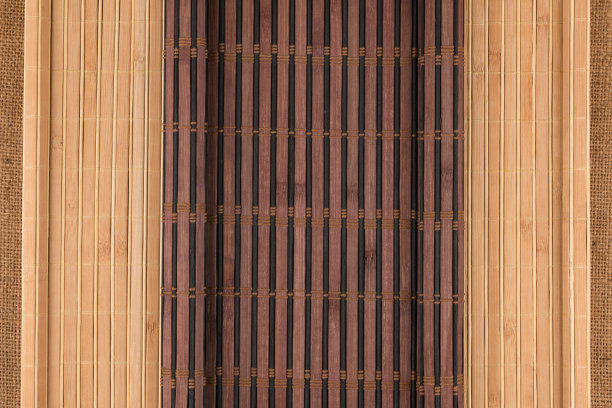 粗麻布上铺着黑亮的竹席，呈卷轴状。图片下载