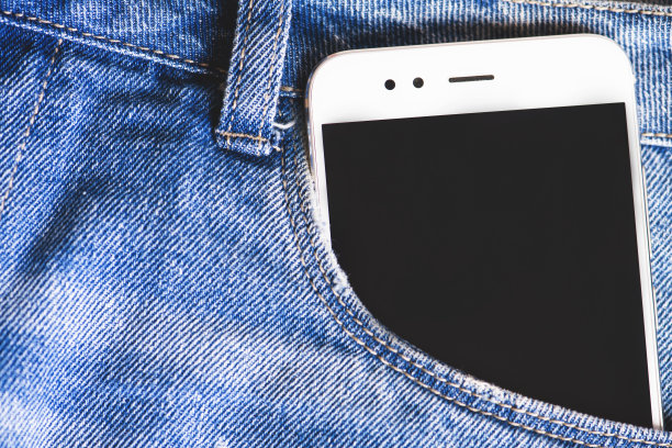 牛仔裤口袋里的白色智能手机图片下载