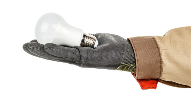 圆形LED灯戴着黑色防护手套放在电工手上，棕色均匀隔离在白色背景上图片下载