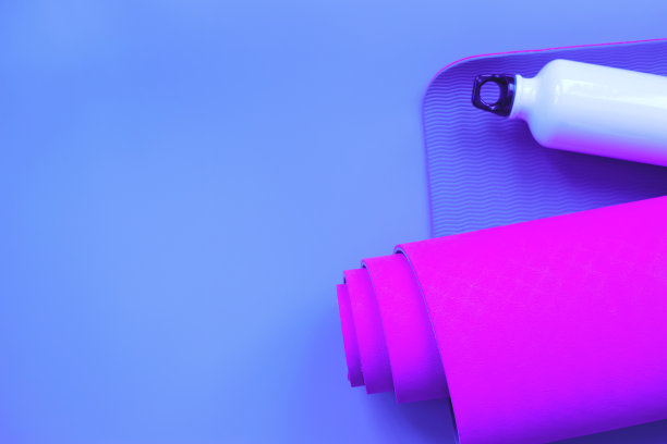 亮紫色瑜伽垫和一瓶水。图片下载